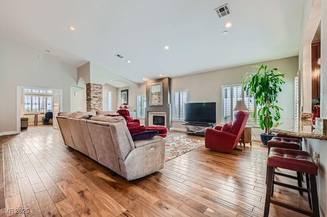8124 Bay Harbor Dr, Las Vegas, NV 89128 - living room with wood-type flooring, a glass covered fireplace, arched walkways, baseboards, and a high ceiling