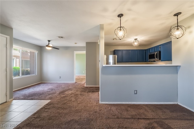 350 S Durango Dr Unit 108, Las Vegas, NV 89145 - kitchen with stainless steel appliances, blue cabinetry, light colored carpet, a ceiling fan, and pendant lighting