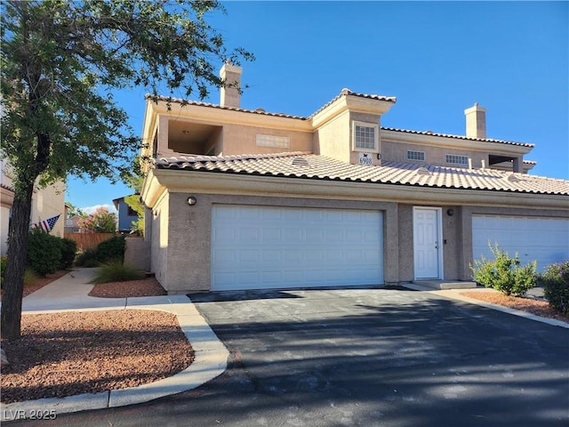 view of front of home featuring stucco siding, asphalt driveway, an attached garage, and a tile roof