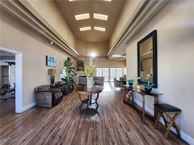6908 Dorita Ave Unit 101, Las Vegas, NV 89108 - living room featuring wood finished floors, a high ceiling, baseboards, and a skylight