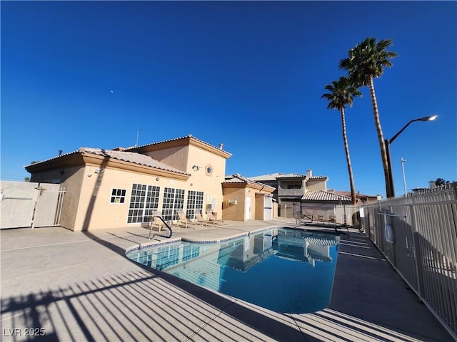 view of swimming pool with a patio and fence