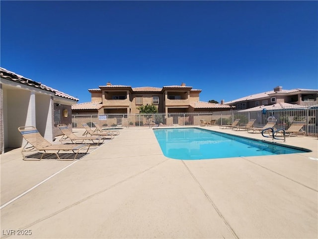 community pool featuring fence and a patio area