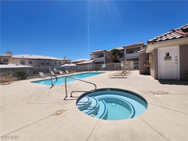 community pool with a community hot tub, a patio, and fence