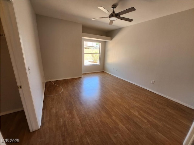 empty room with dark wood-type flooring, ceiling fan, and baseboards