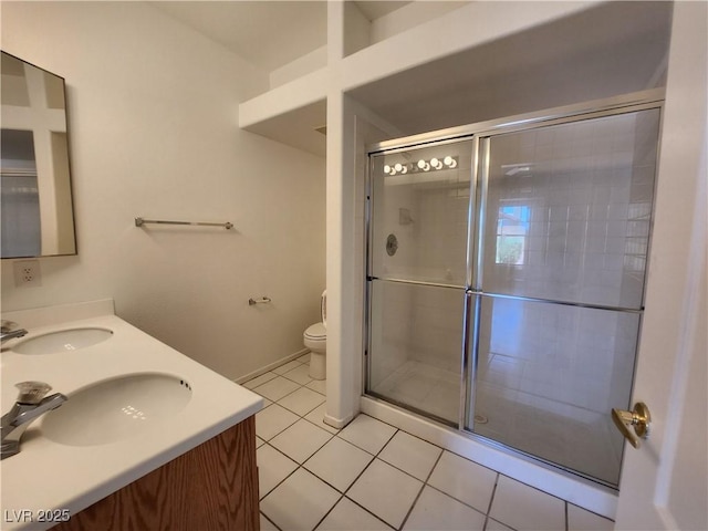 bathroom with a stall shower, tile patterned floors, toilet, and double vanity