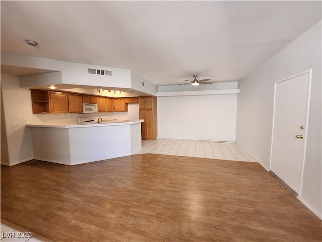 unfurnished living room with light wood finished floors and a ceiling fan