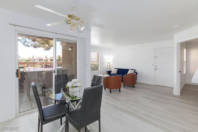 dining space with light wood-type flooring, ceiling fan, and baseboards