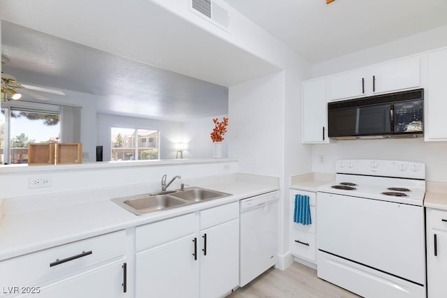 kitchen featuring white appliances, a sink, white cabinets, and light countertops