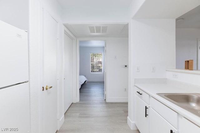 bathroom with wood finished floors, vanity, and baseboards