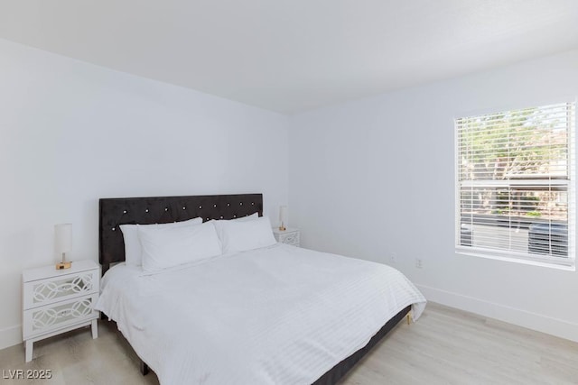 bedroom with light wood-type flooring and baseboards