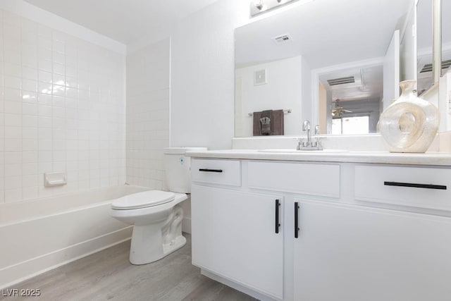 full bathroom with wood finished floors, toilet, vanity, and ceiling fan