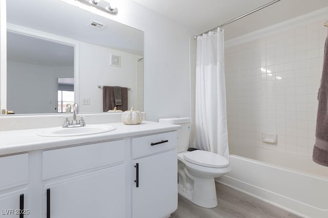 full bath with wood finished floors, vanity, toilet, and shower / bath combo with shower curtain