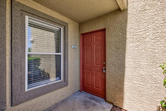 property entrance with stucco siding