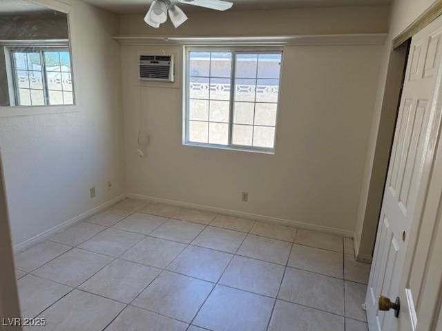 empty room with ceiling fan, light tile patterned flooring, an AC wall unit, and plenty of natural light