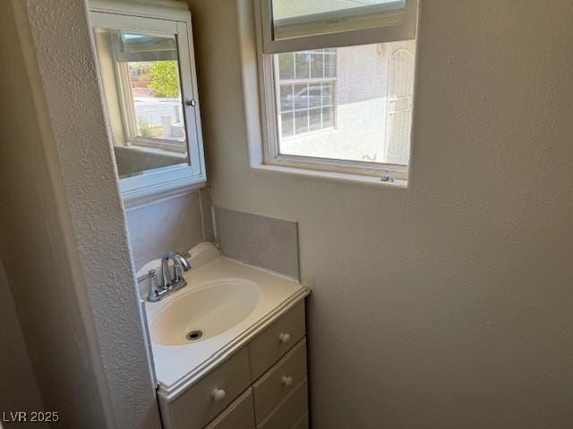 bathroom featuring vanity and a textured wall