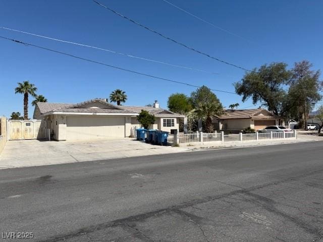 ranch-style house featuring an attached garage, fence, and concrete driveway