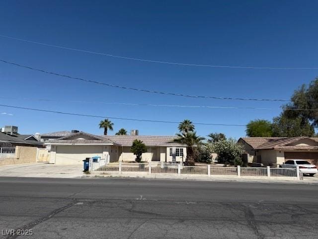 view of front facade with a garage, driveway, and a fenced front yard