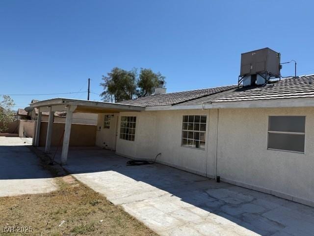 back of house with central AC, stucco siding, and fence