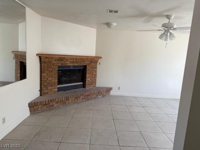 unfurnished living room featuring a fireplace, a ceiling fan, tile patterned floors, and baseboards