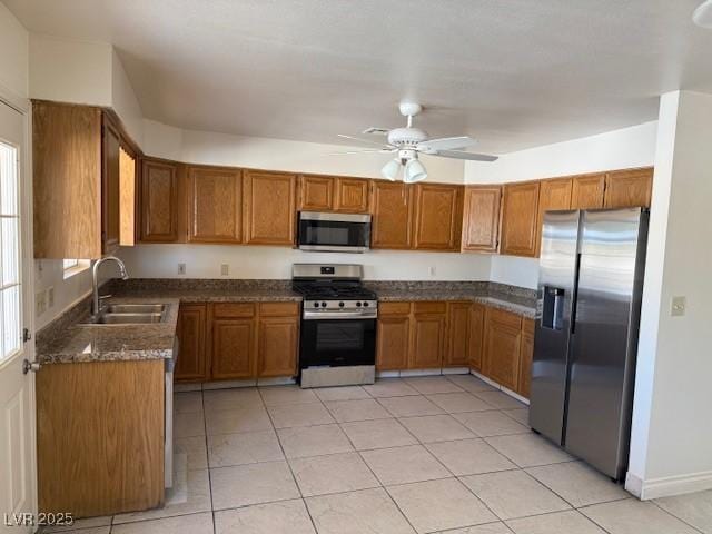kitchen featuring stainless steel appliances, a sink, and brown cabinetry