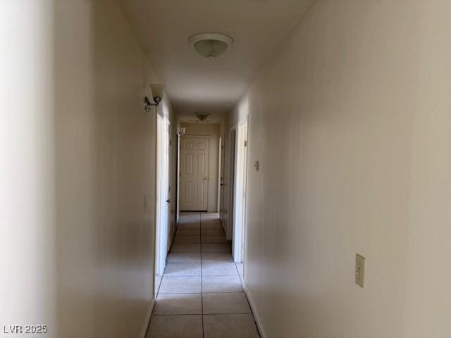 corridor with light tile patterned floors and baseboards