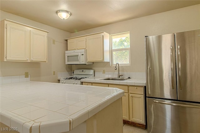 5170 S Pearl St, Las Vegas, NV 89120 - kitchen with white appliances, a sink, tile countertops, and a peninsula