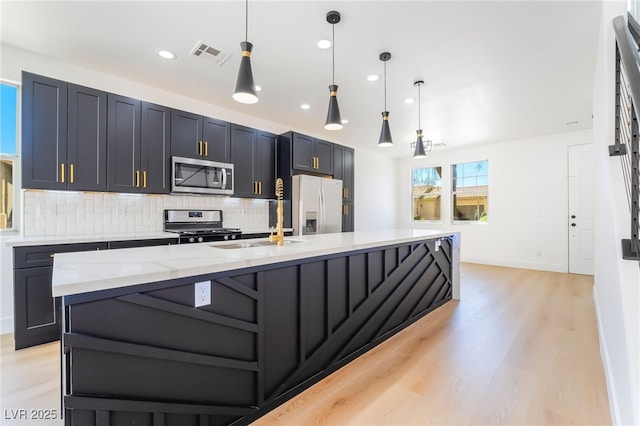 529 Fork Mesa Ct, Henderson, NV 89015 - kitchen with stainless steel appliances, decorative backsplash, a large island, a sink, and light stone countertops