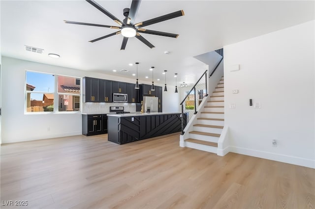 529 Fork Mesa Ct, Henderson, NV 89015 - kitchen featuring appliances with stainless steel finishes, dark cabinets, light countertops, light wood-type flooring, and ceiling fan
