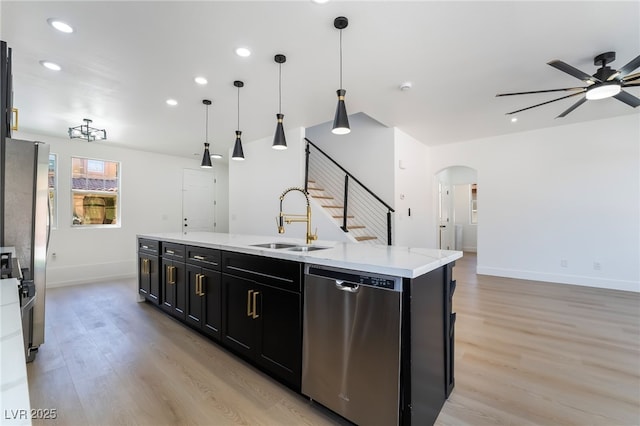 529 Fork Mesa Ct, Henderson, NV 89015 - kitchen with stainless steel dishwasher, a sink, ceiling fan, dark cabinetry, and arched walkways