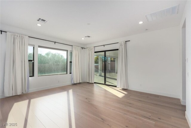 spare room featuring light wood-type flooring, recessed lighting, and baseboards