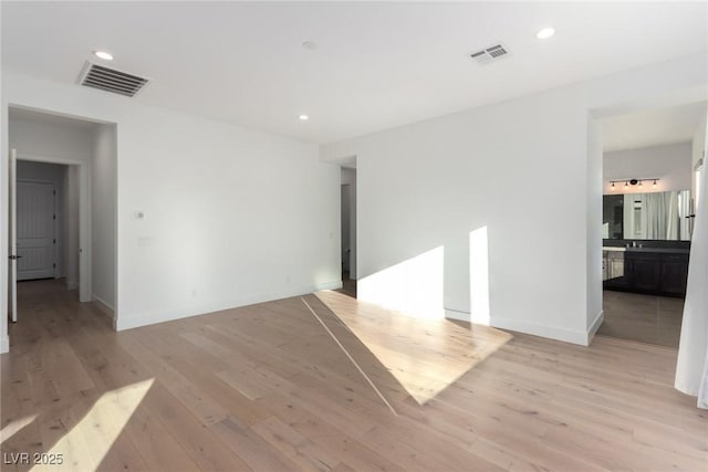 unfurnished room featuring light wood-style flooring, baseboards, and recessed lighting