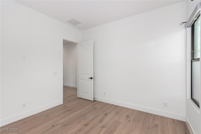 empty room featuring baseboards and light wood-style flooring
