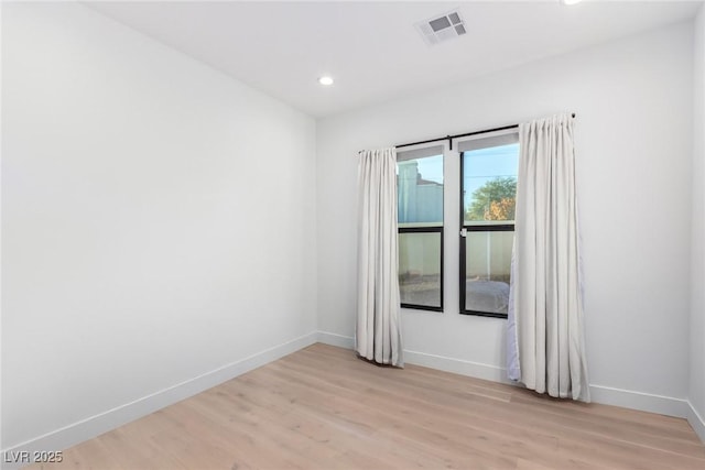 unfurnished room featuring light wood-style flooring, baseboards, and recessed lighting
