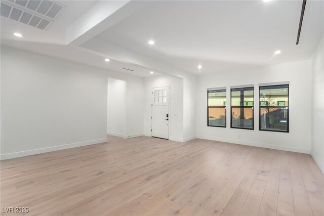 empty room with light wood-style floors, recessed lighting, and baseboards