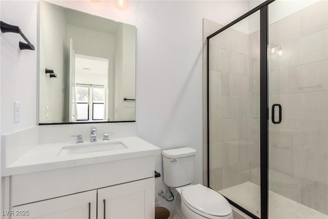 full bath featuring a stall shower, toilet, and vanity