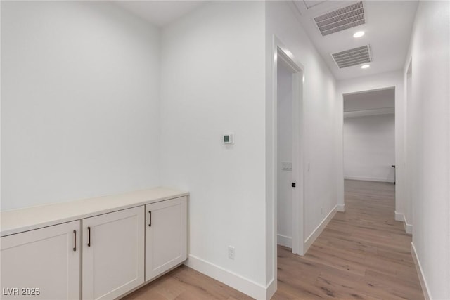 hall featuring light wood-style floors, baseboards, and recessed lighting