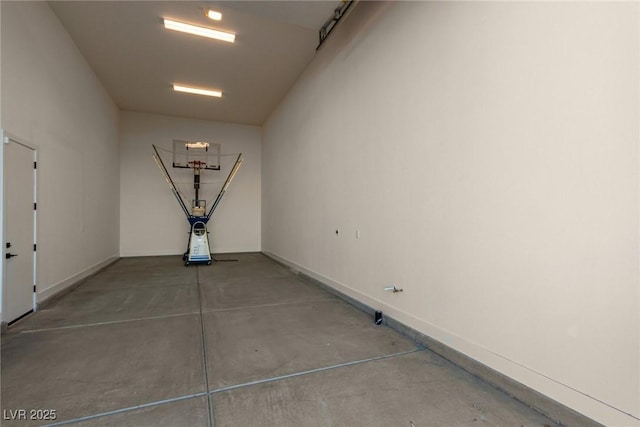 hall featuring concrete floors and baseboards