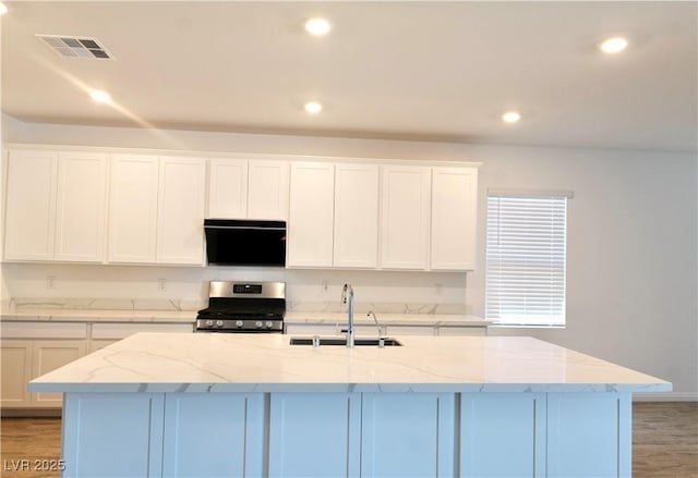 6250 Lamont Hills Ave, Las Vegas, NV 89139 - kitchen featuring stainless steel range, white cabinets, a center island with sink, recessed lighting, and light stone counters