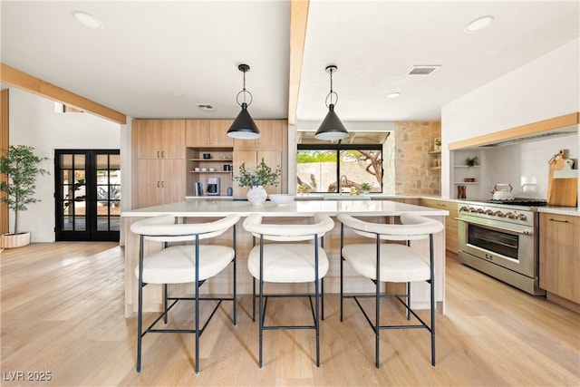 kitchen featuring open shelves, high end stainless steel range, modern cabinets, light countertops, and recessed lighting