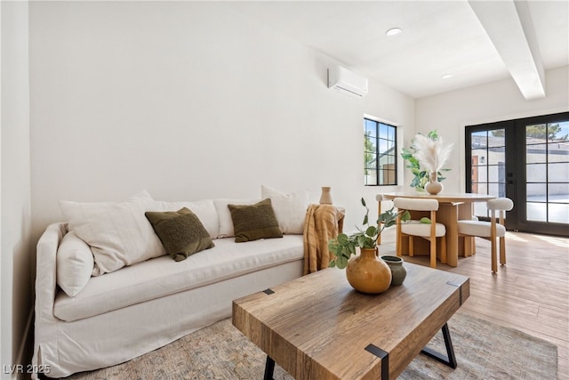 living room featuring a wall unit AC, light wood finished floors, french doors, recessed lighting, and beamed ceiling
