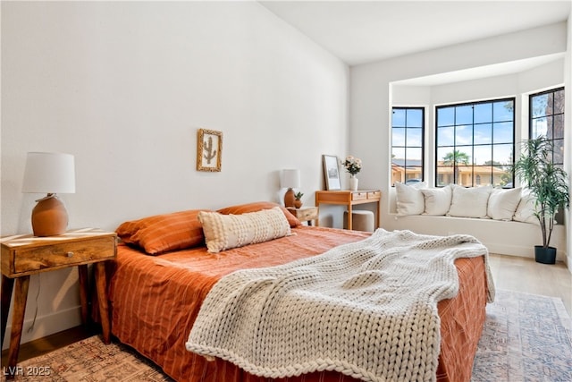 bedroom featuring light wood finished floors and baseboards