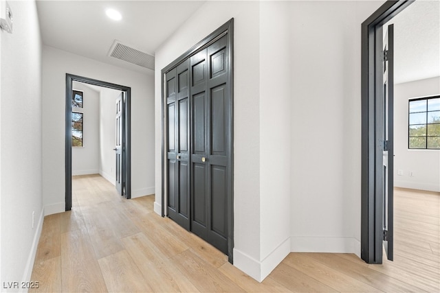hallway with light wood-style flooring and baseboards