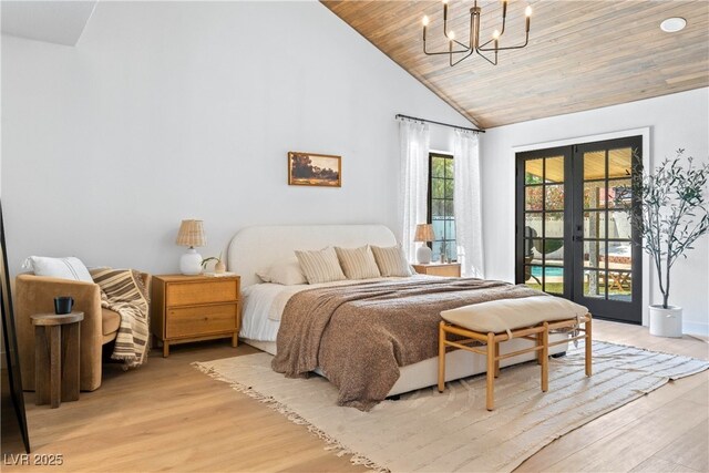 bedroom featuring access to exterior, french doors, light wood finished floors, a chandelier, and high vaulted ceiling