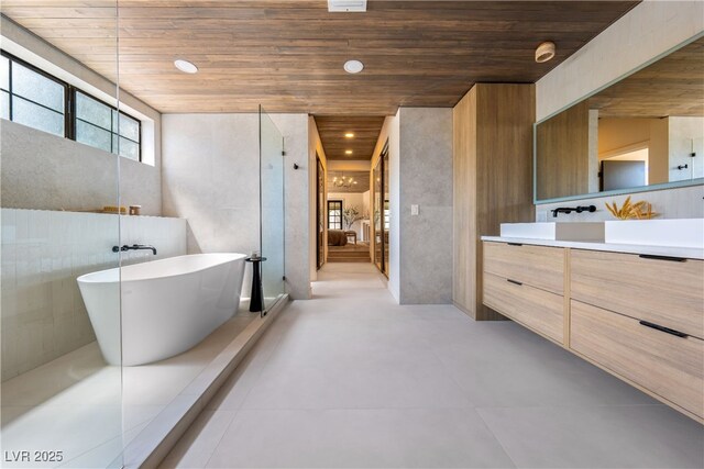 bathroom featuring wood ceiling, vanity, and a soaking tub