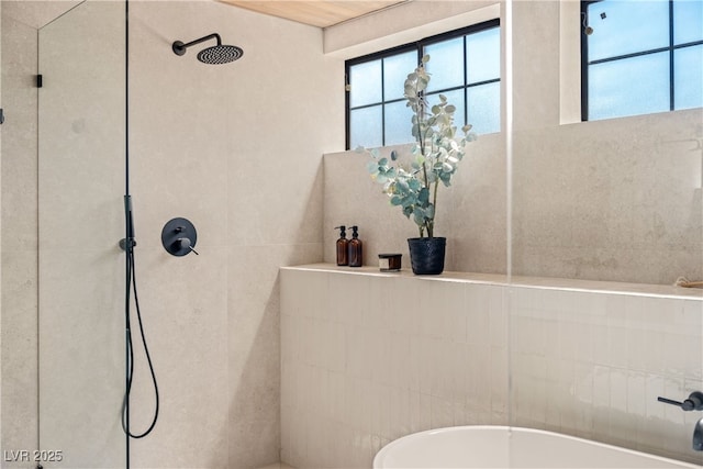 full bathroom with a freestanding bath, a tile shower, healthy amount of natural light, and tile walls