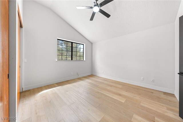 unfurnished bedroom with light wood-type flooring, lofted ceiling, a ceiling fan, and baseboards