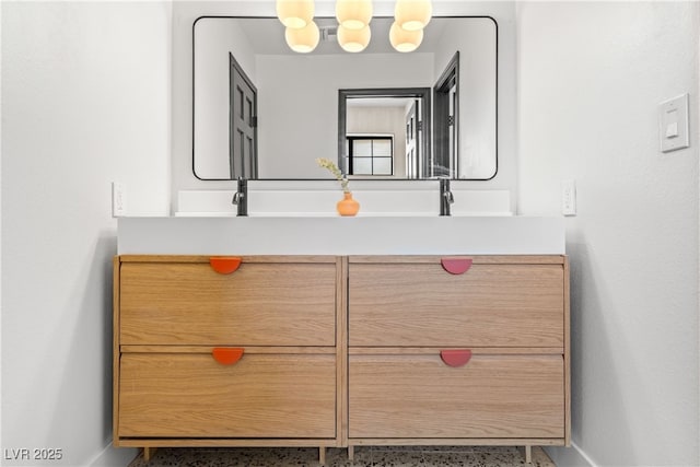 bathroom with baseboards, speckle patterned floor, and vanity