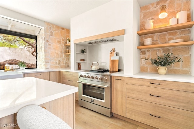 kitchen with high end stainless steel range, open shelves, modern cabinets, and light countertops