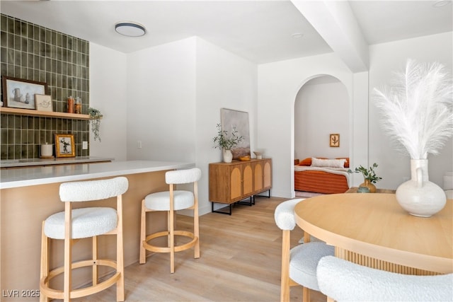 dining room featuring light wood-style floors and arched walkways