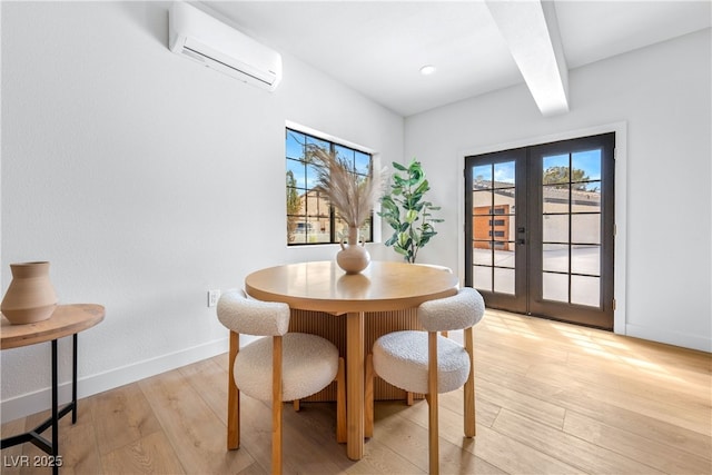 dining room with french doors, beam ceiling, light wood finished floors, an AC wall unit, and baseboards
